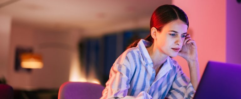 Focused woman working over the laptop at the office, feeling weary